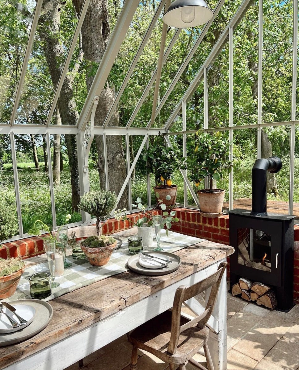 Bioethanol fireplace with false flue next a wooden dining table
