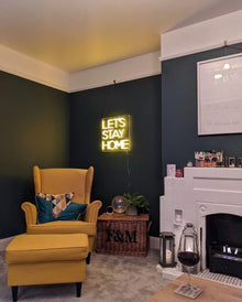 Black bioethanol fireplace in white insert in a living room with yellow chair and pouffe