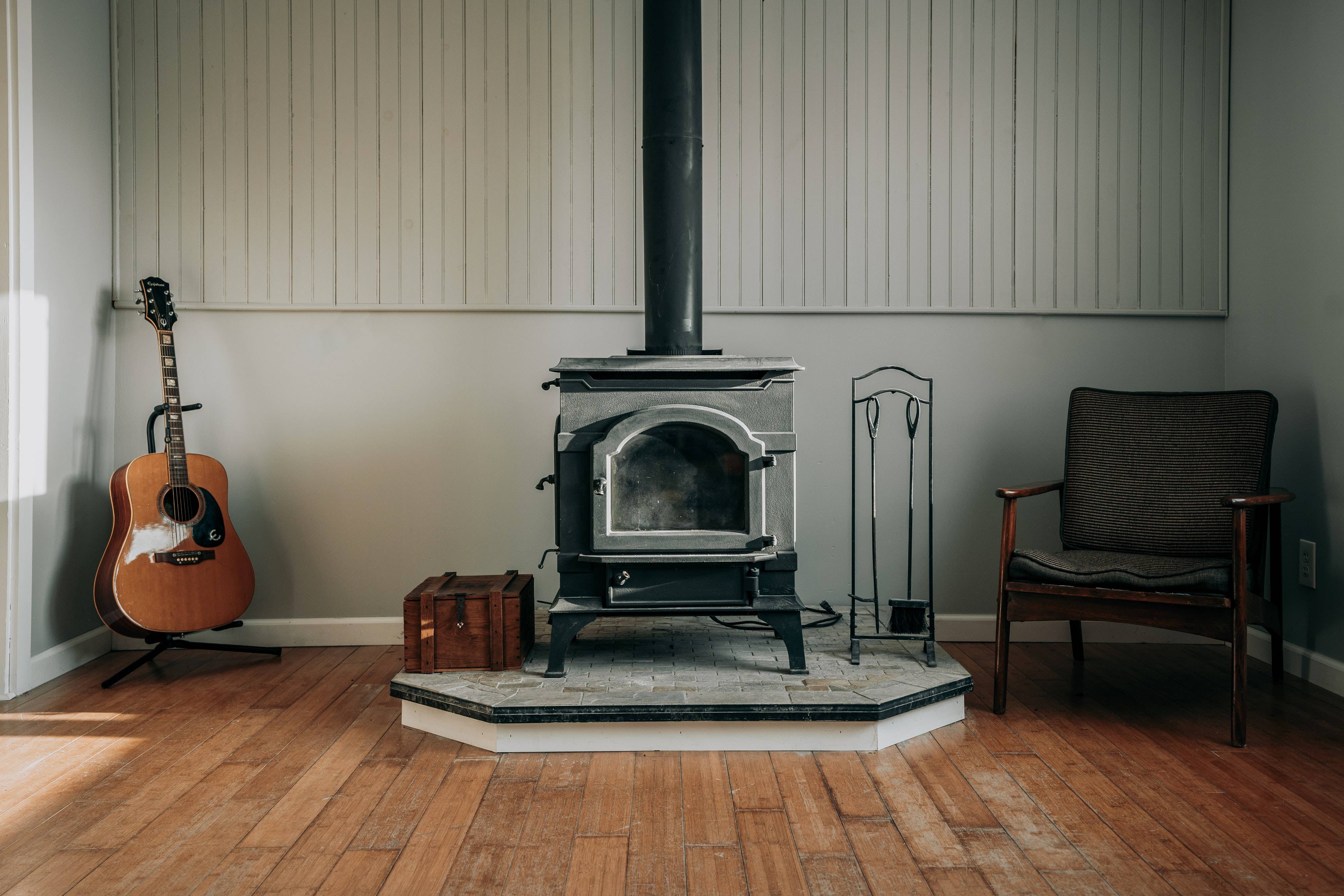 Old fireplace in old house between guitar and chair