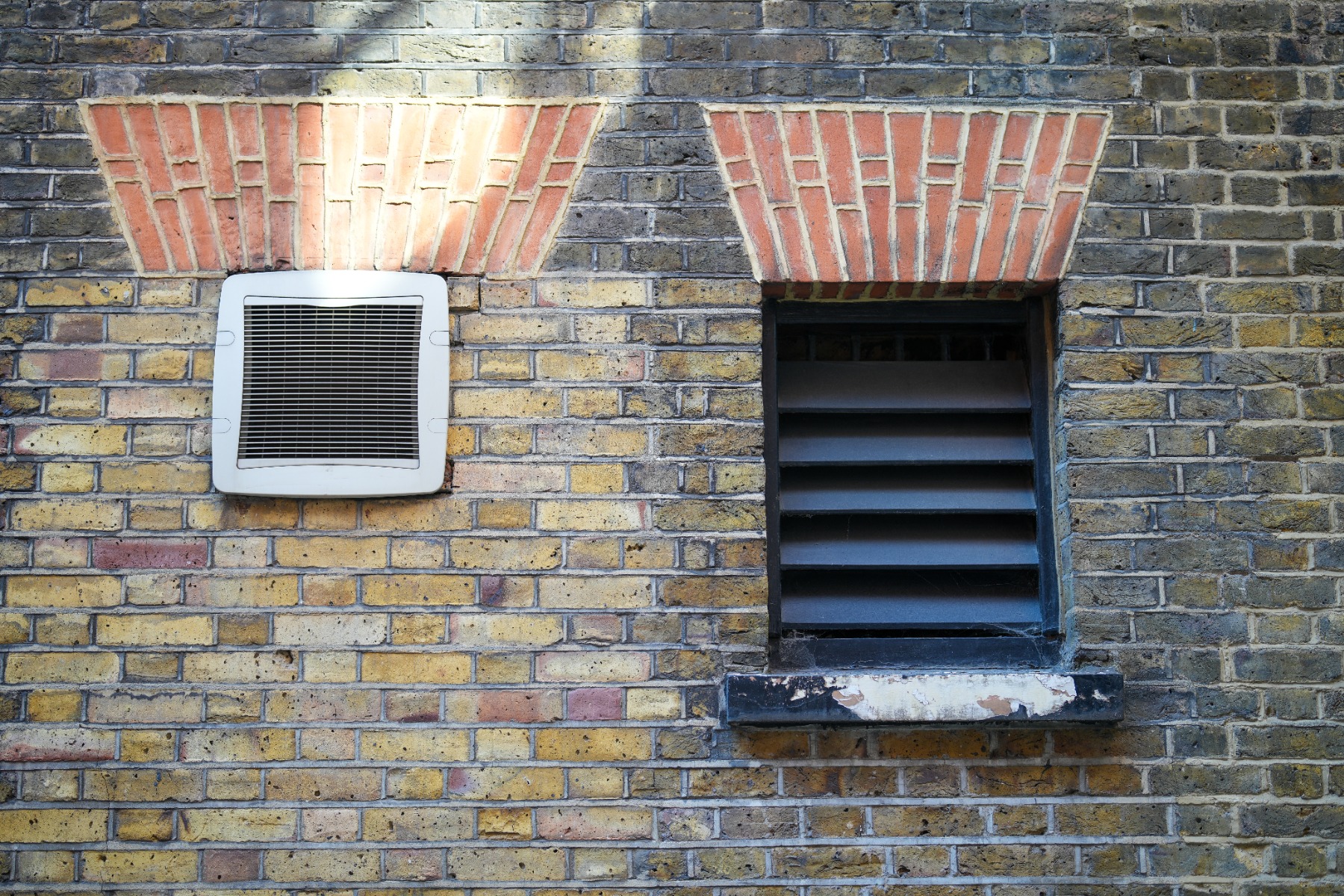 Different types of ventilation installed into a brick wall