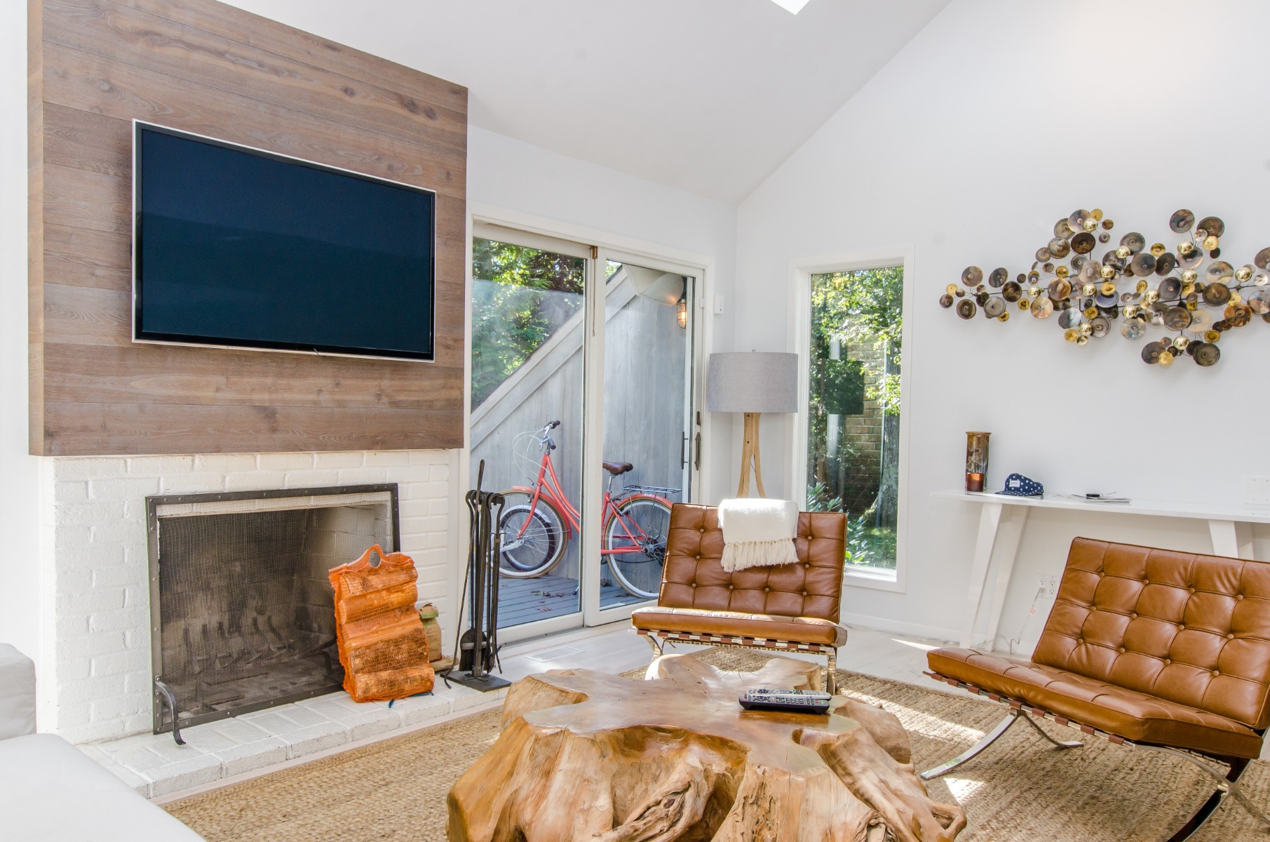 White feature fireplace wall in a living room with TV and two brown chairs