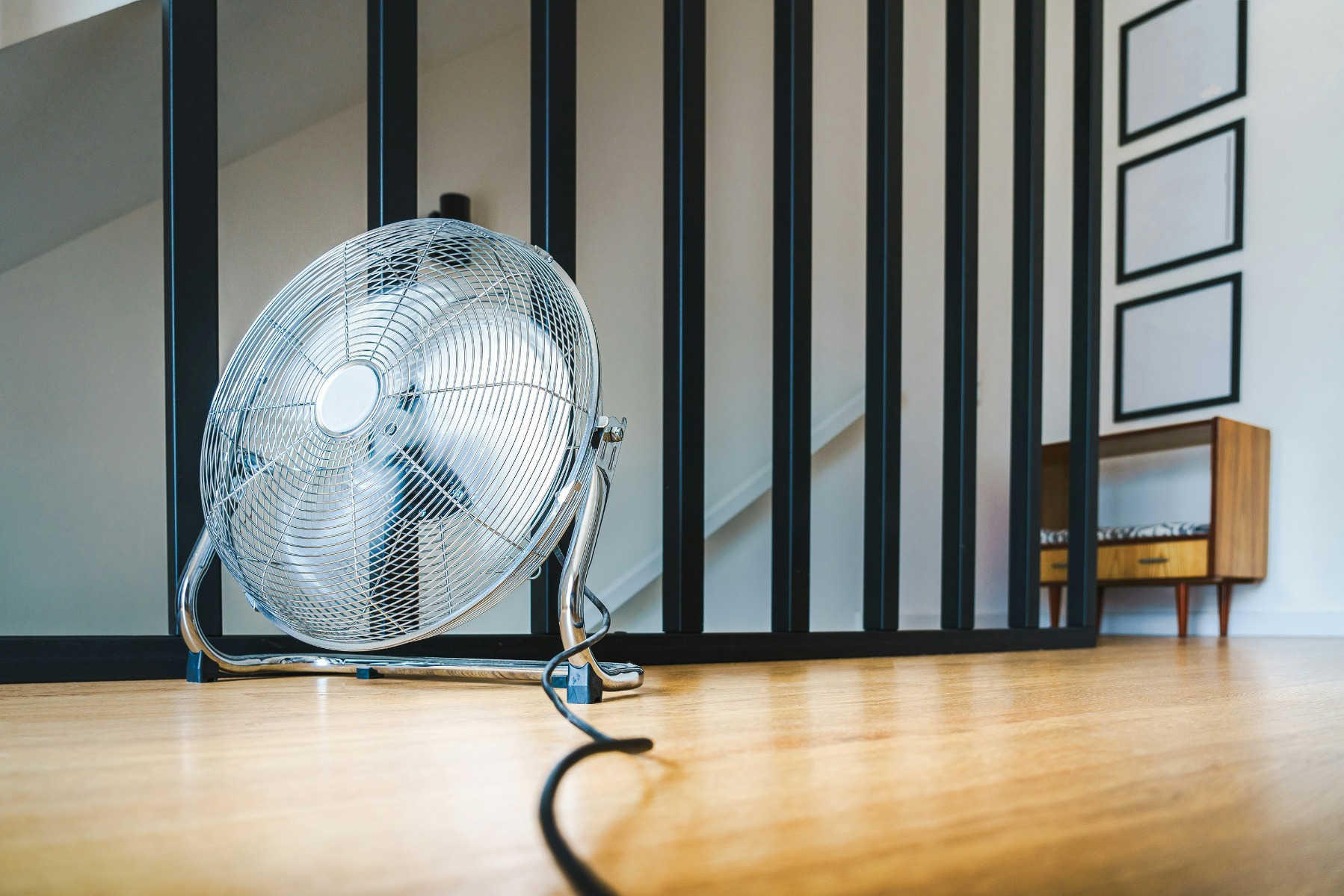 Metallic floor fan with a black cable