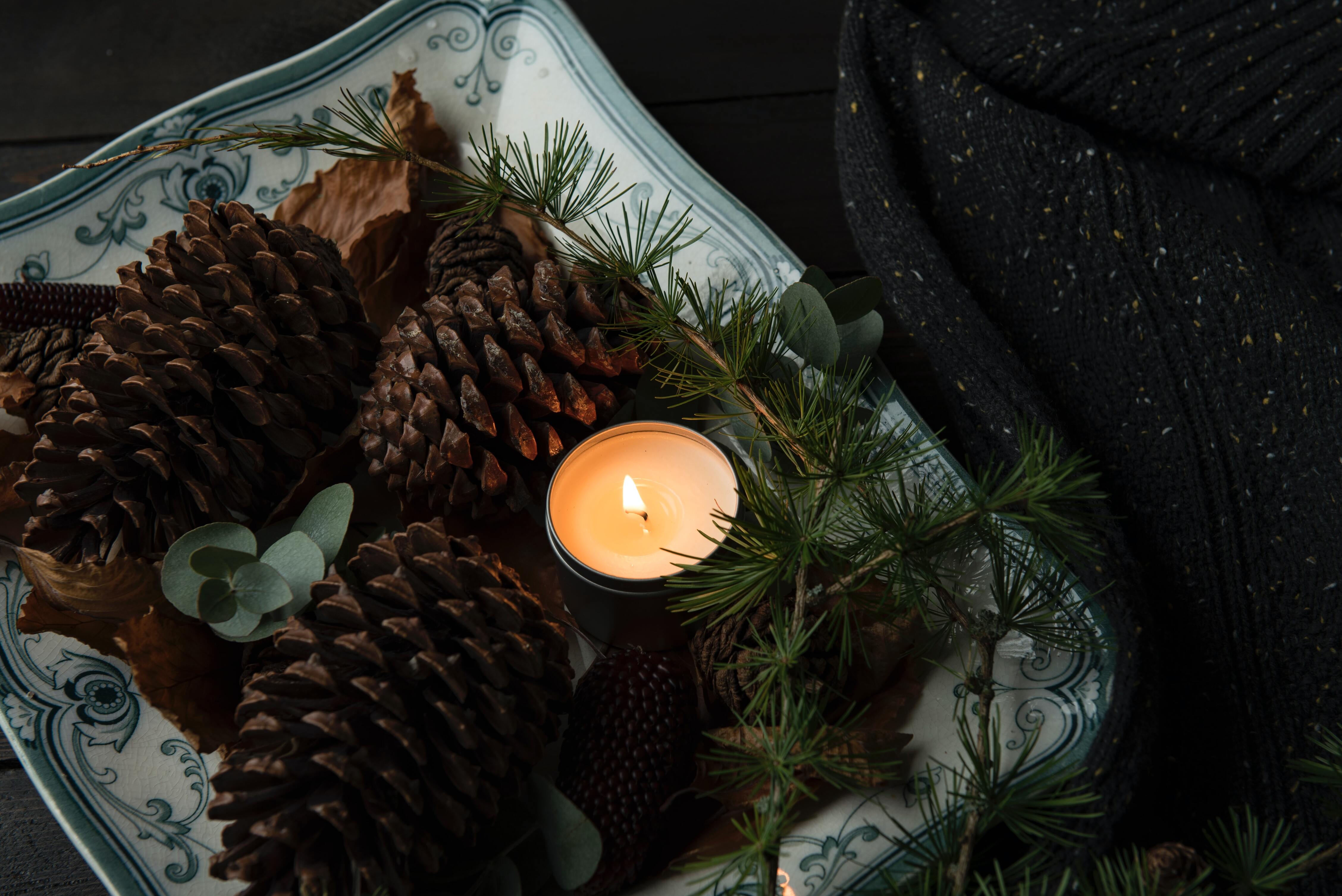Tea light on a tray with pinecones