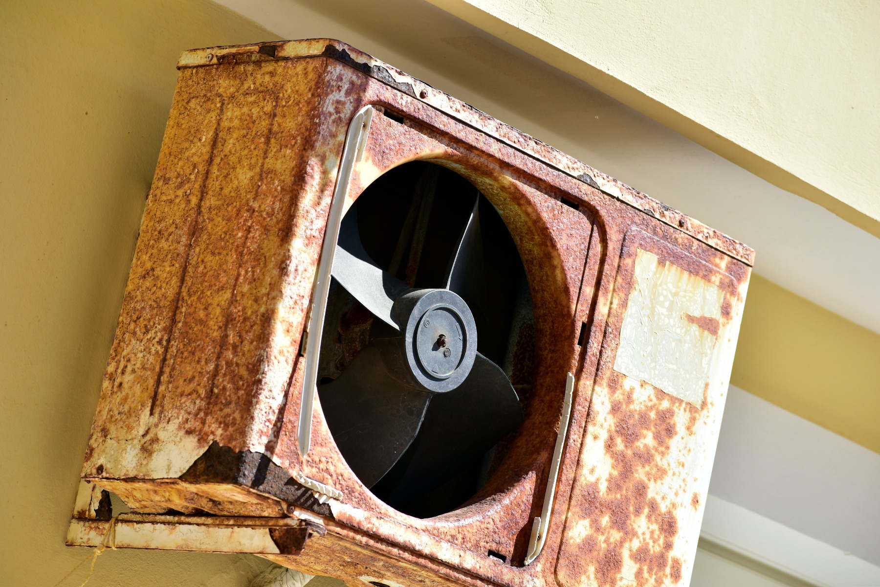 Rusty metal fan mounted on the wall